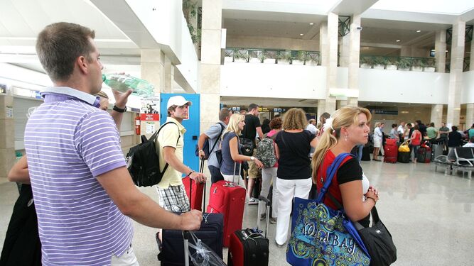 Turistas extranjeros esperan para facturar en las instalaciones del aeropuerto de Jerez.