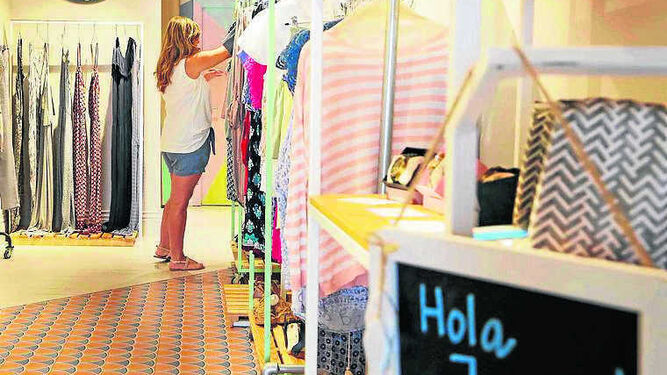 Una mujer observa las prendas de un negocio de moda en la céntrica calle Larga.