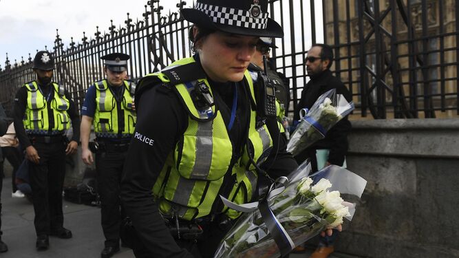 Policías depositan ayer flores cerca del Parlamento en Londres en memoria de su compañero apuñalado y los dos viandantes atropellados.