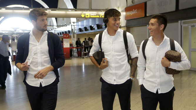 Franco Vázquez, Joaquín Correa y Matías Kranevitter, sonrientes antes de embarcar en el vuelo que los llevó a Barcelona.