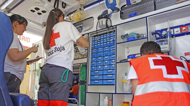 Voluntarios de la Cruz  Roja  de Jerez en una de las ambulancias..