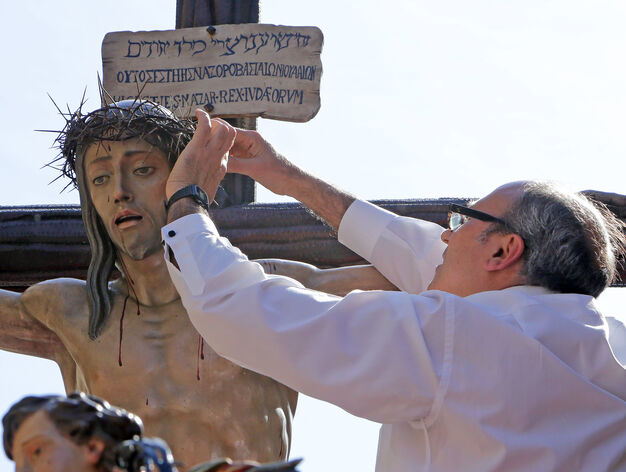 Un hermano ajusta la corona de espinas al Cristo del Perd&oacute;n. El fuerte viento lleg&oacute; a tir&aacute;rsela. La foto est&aacute; tomada en la Calzada del Arroyo.
