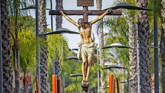 Preciosa estampa del Cristo de la Defensión entre las palmeras del bulevar de la calle Sevilla.