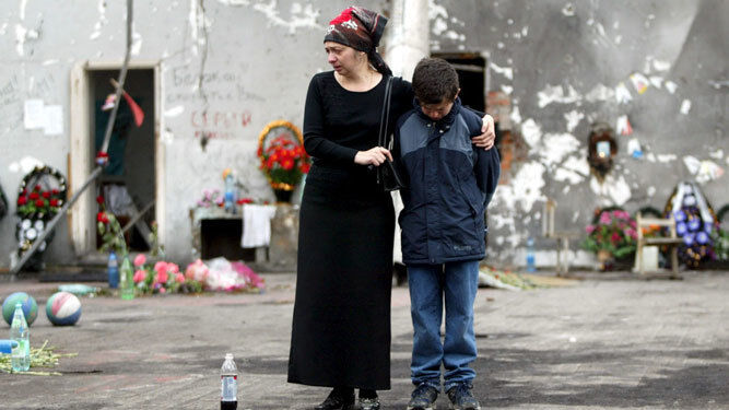 Familiares de un joven fallecido, en el patio de la escuela de Beslán.