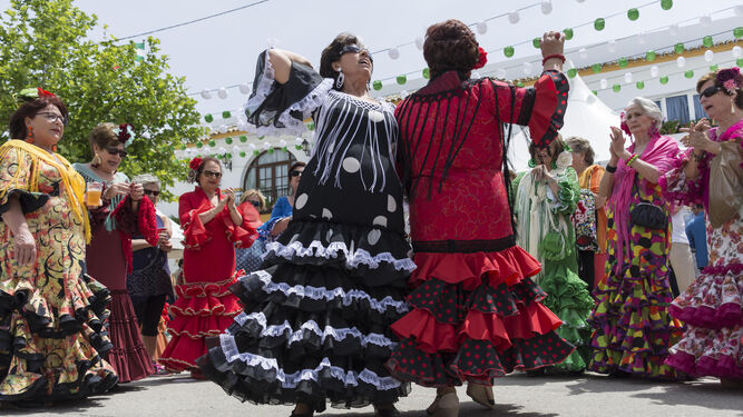 Dos mujeres bailan sevillanas en el primer día de la feria roteña.