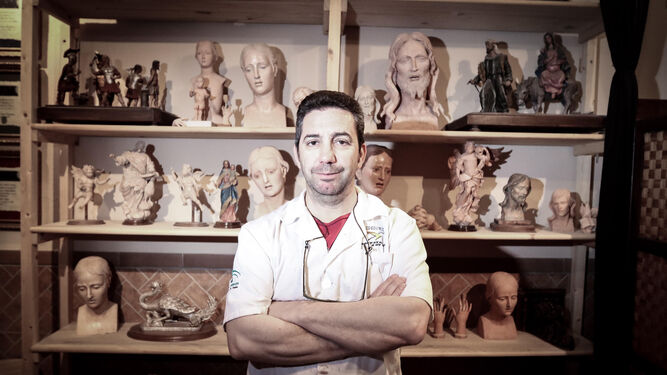 Antonio López Ramírez, maestro escultor e imaginero, en su taller junto a bocetos de obras suyas.