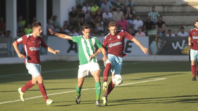 Dos futbolistas del Arcos presionan a un jugador verdiblanco.