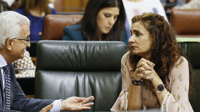 Los consejeros Manuel Jiménez Barrios y María Jesús Montero conversan ayer en el Parlamento.