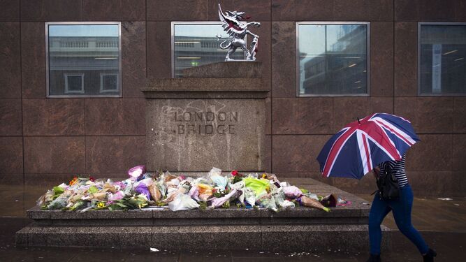 Una mujer pasa ante un homenaje a las víctimas del ataque en Londres.