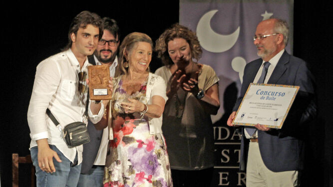 Cristina Heeren y Alberto Marina entregan al sevillano Adrián Domínguez el trofeo y la beca conseguida como ganador.