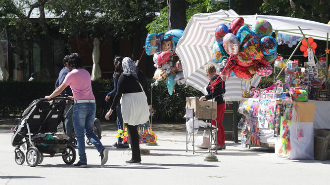 Una mujer pasea con el carrito  de sus hijos en el madrileño parque de El Retiro.