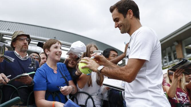 Federer firma autógrafos.