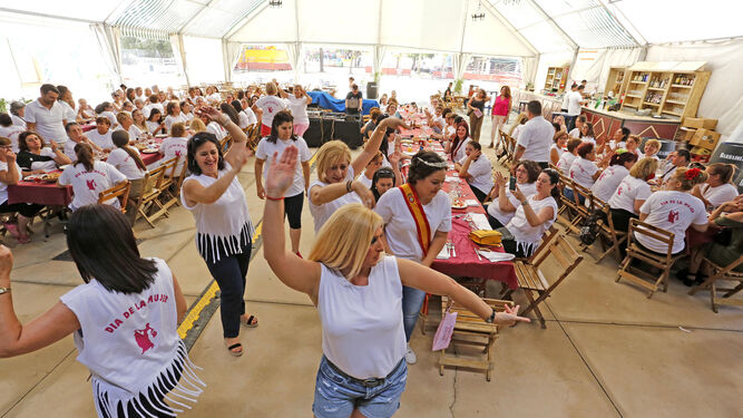 Un grupo de mujeres baila una sevillana durante el tradicional almuerzo en la Caseta Municipal de San Isidro.