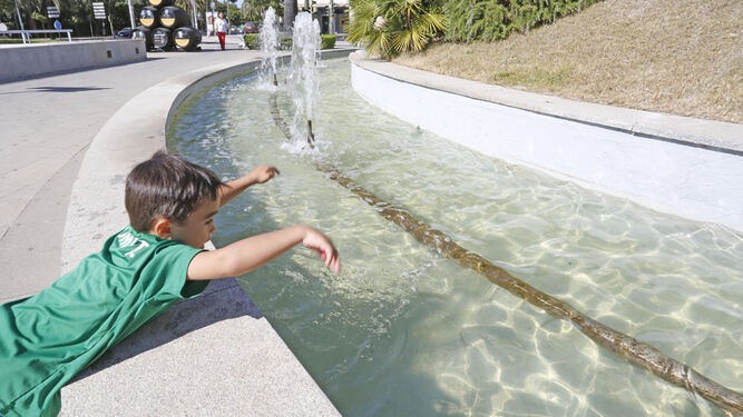 Un niño juega con el agua de la fuente de la Plaza del Caballo, ayer.
