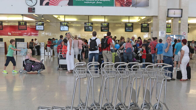 La terminal de salidas del aeropuerto de Jerez con numerosos pasajeros haciendo colas.