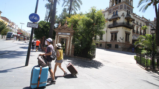 Dos turistas cargas con sus maletas por Sevilla.