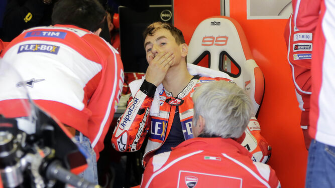 Jorge Lorenzo, con gesto serio en el box de Ducati junto a miembros de su equipo.