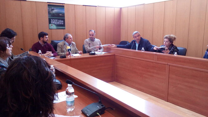 El secretario del Ayuntamiento recibe un documento de un edil del PP durante el pleno de la votación de la moción de censura, con el popular Antonio García presidiendo la sesión.