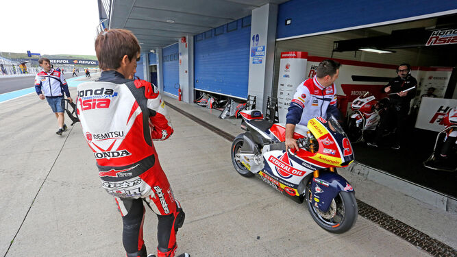 El japonés Tetsuta Nagashima observa la moto del español Jorge Navarro.