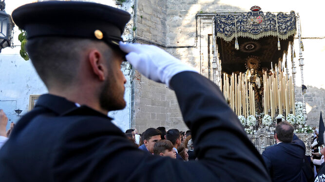 Un agente del Cuerpo Nacional de Polic&iacute;a se cuadra ante la imagen de la Virgen de Confortaci&oacute;n saliendo de Santo Domingo.