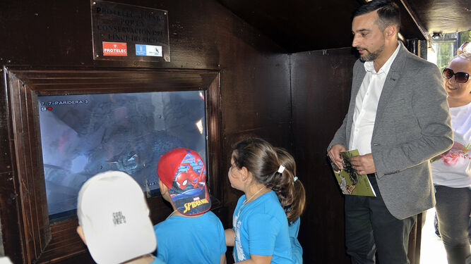 El teniente de alcaldesa de Sostenibilidad, José Antonio Díaz, y varios niños observan ayer las crías a través del monitor.
