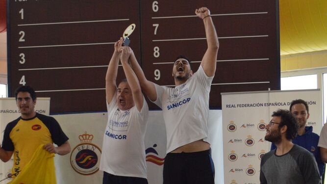 Carlos Rigual y Roberto García levantan emocionados la copa de campeones en categoría masculina.