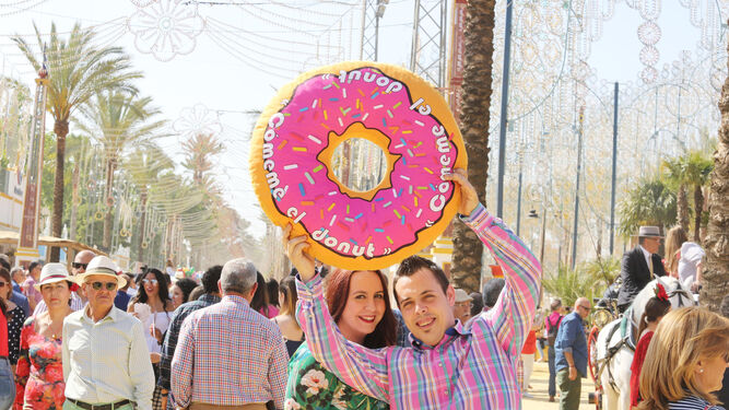 Una pareja muestra el &lsquo;donut&rsquo; que han conseguido en la Feria.