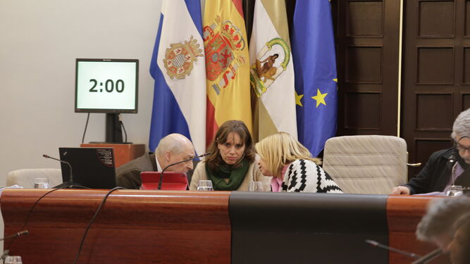 La alcaldesa conversa con el interventor municipal en presencia de la primera teniente de alcaldesa en un pleno.