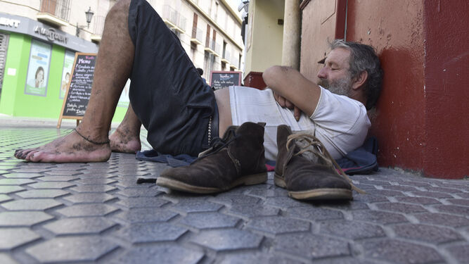 Un hombre duerme en el suelo en plena calle.