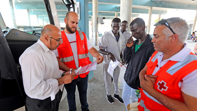 Voluntarios de Cruz Roja junto a los inmigrantes momentos antes de subir ayer al autobús.