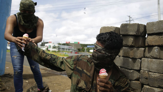 Dos manifestantes comparten un helado a las afueras de Managua.
