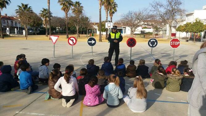 Un policía local enseña a escolares el significado de señales de tráfico.