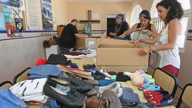 Voluntarios preparan ropa donada para los migrantes en la parroquia de Pescadores, en Algeciras, ayer.