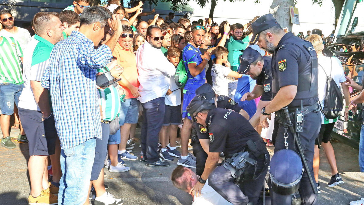 Agentes de la Policía nacional retienen a un aficionado que intentó saltarse el cordón policial.