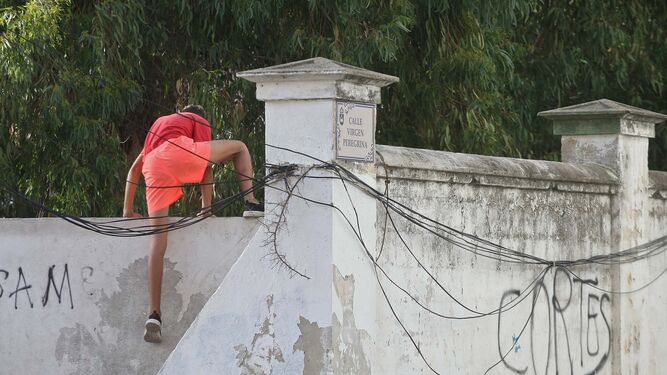 Un joven salta el muro perimetral del centro de menores La Concepción en La Línea, el martes.
