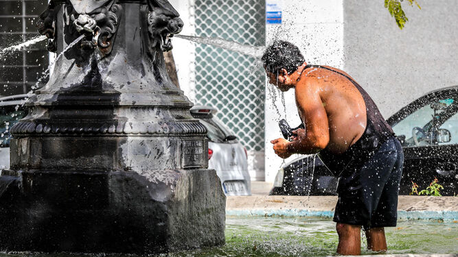 Un hombre se refresca en una fuente de Jerez para dar esquinazo al calor.