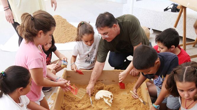 Francisco Barrionuevo explicando a los niños cómo hacer la excavación.