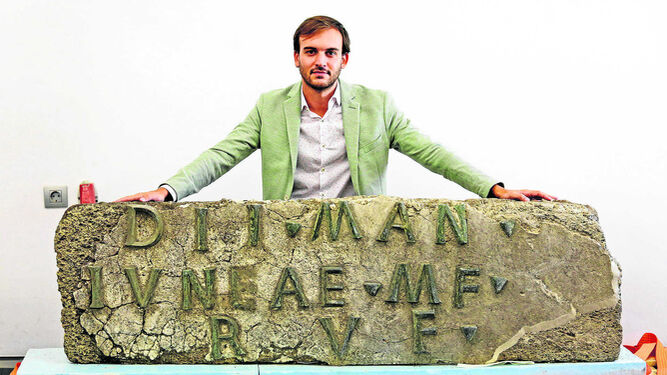 El delegado territorial de Cultura, Daniel Moreno posa ante el último gran hallazgo en Baelo Claudia, una inscripción funeraria única en Hispania.