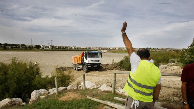 Un operario llama a un camión cargado de materiales durante unas obras en la zona de Torrox.