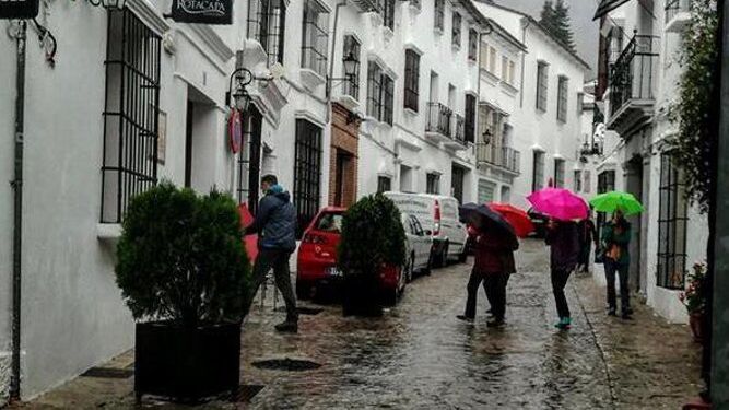 Vecinos de Grazalema se protegen de la lluvia, en una imagen de archivo.