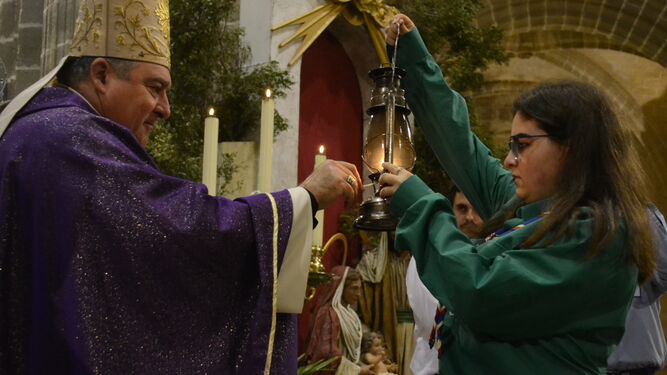 El obispo enciende uno de los candiles en una edición anterior de la Luz de la Paz de Belén.