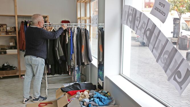 'Snorre' ordena la ropa en su tienda de artículos vintage.
