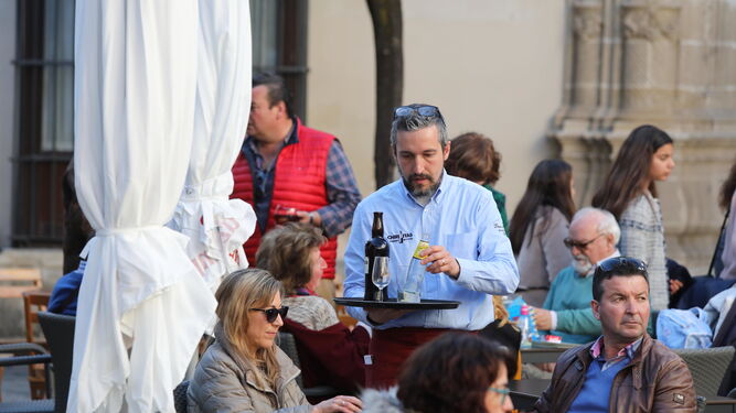 Un camarero atiende a una mesa de clientes en una terraza del centro de Jerez.