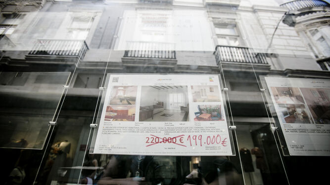 Cartel de una vivienda a la venta en una inmobiliaria de Cádiz.