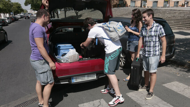 Varios viajeros comparten un coche cerca de la estación de Santa Justa.