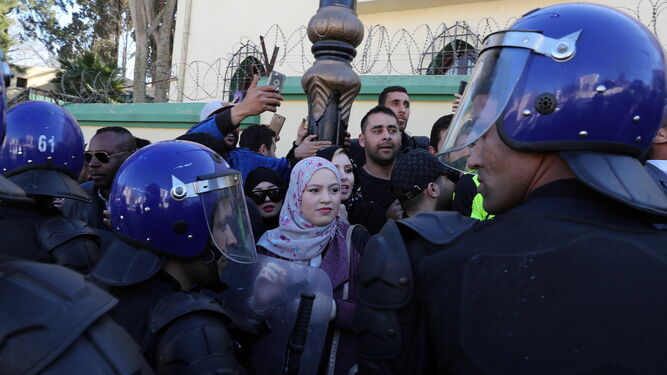 Varios policías controlan ayer en Argel a los manifestantes que protestaban contra el presidente Buteflika.