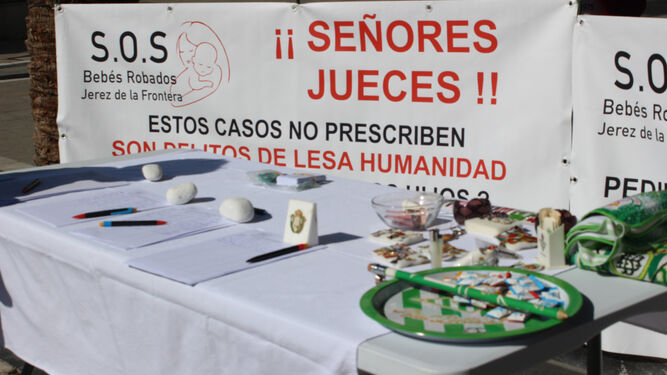 Pancarta y mesa informativa de ‘SOS Bebés Robados’ de Jerez.