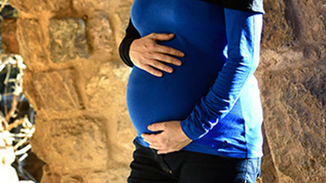 Una mujer embarazada se toca la barriga.