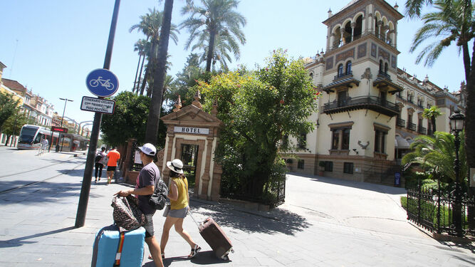 Dos turistas pasan por delante del Hotel Alfonso XIII.