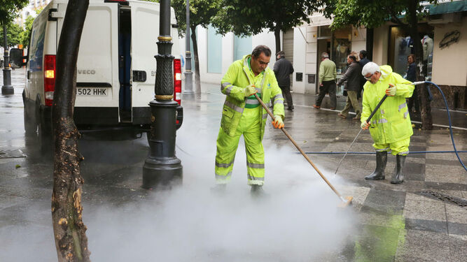 Dos empleados de Urbaser realizan labores de limpieza en la calle Larga.